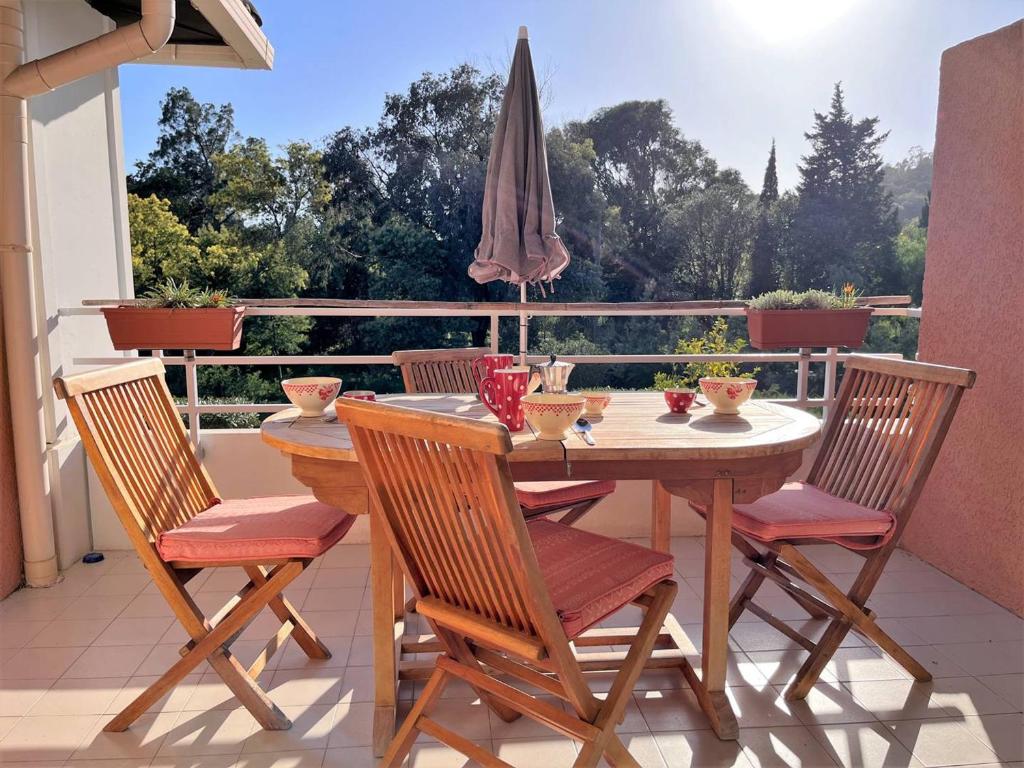 une table et des chaises sur un balcon avec un parasol dans l'établissement Duplex 3 pièces avec grandes terrasses et parking - 6 couchages - proche plage, Le Lavandou - FR-1-251-534, au Lavandou