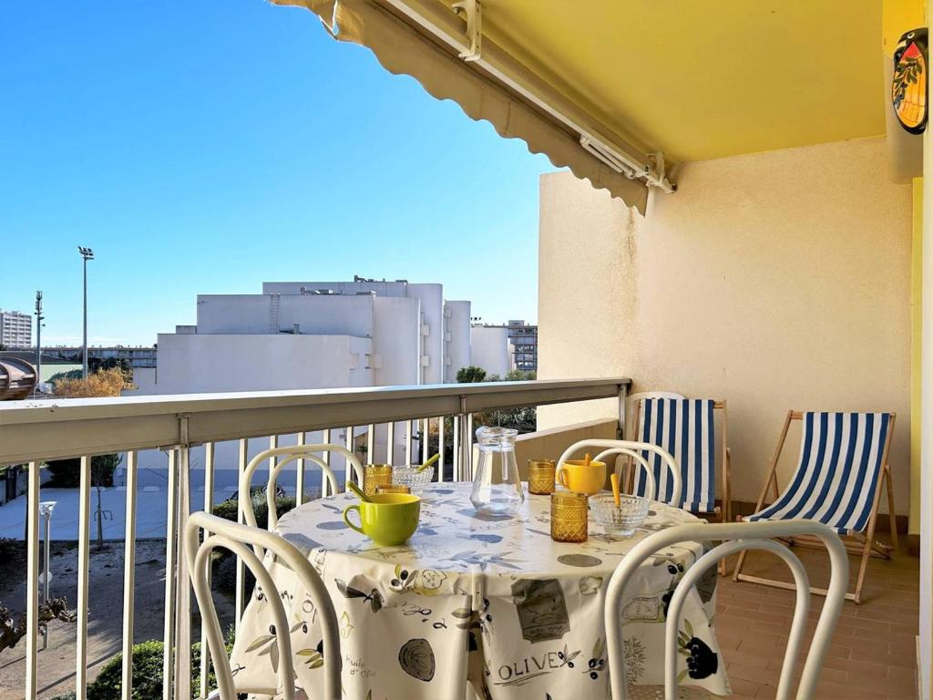 une table et des chaises assises sur un balcon dans l'établissement Appartement 2 pièces, 4 couchages - Terrasse, parking, proche plage - Le Lavandou - FR-1-251-543, au Lavandou