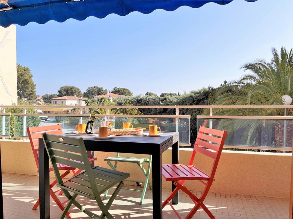 une table et des chaises sur un balcon avec vue dans l'établissement Charmant T2 avec terrasse, clim et garage à Bormes-les-Mimosas, 2 piscines, proche plage et calme - FR-1-251-542, à Bormes-les-Mimosas