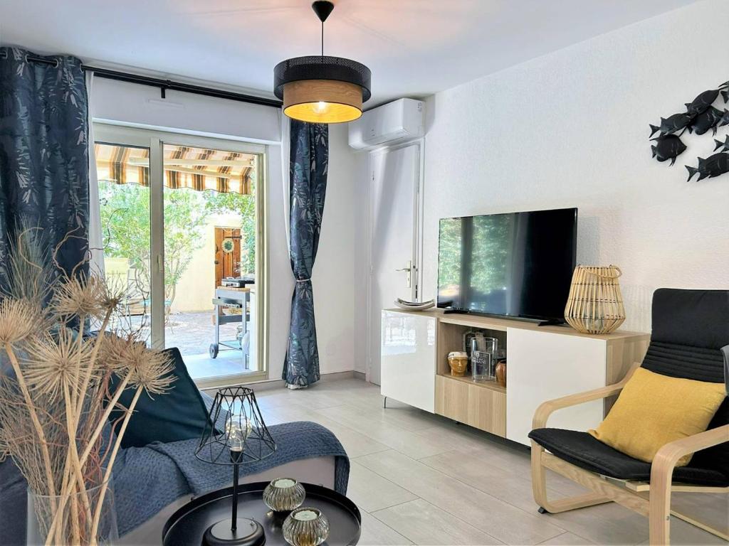uma sala de estar com um sofá e uma televisão em Appartement Bormes-les-Mimosas, 3 pièces, 5 personnes - FR-1-251-575 em Bormes-les-Mimosas
