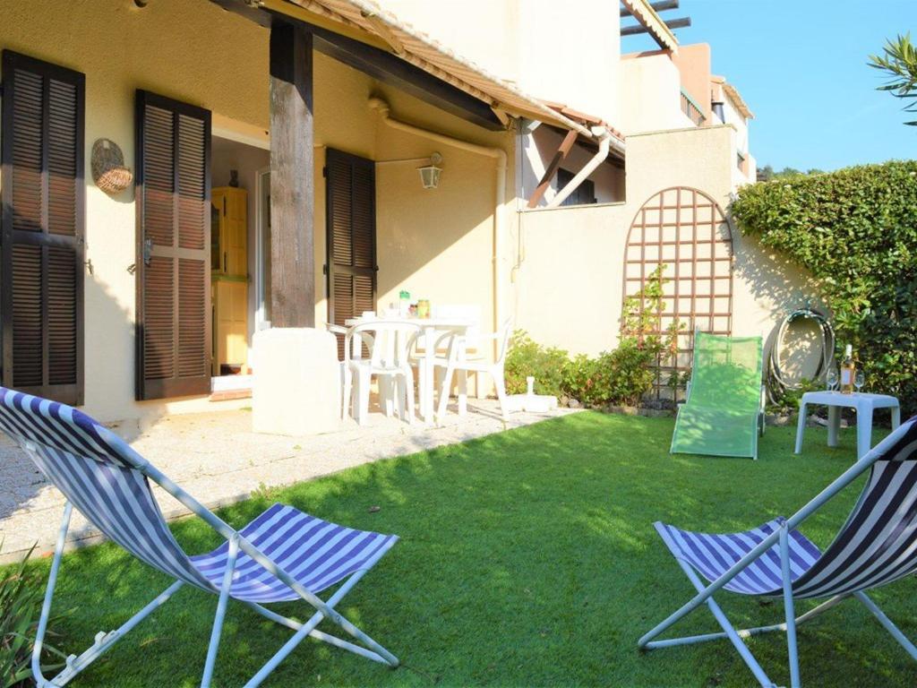 two chairs sitting in the yard of a house at Appartement Le Lavandou, 2 pièces, 4 personnes - FR-1-251-573 in Le Lavandou