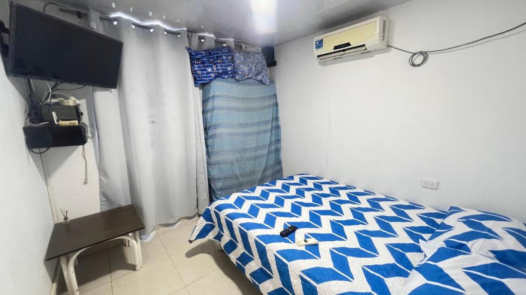 a small room with a bed and a television at Estudio KliBeño in Cartagena de Indias