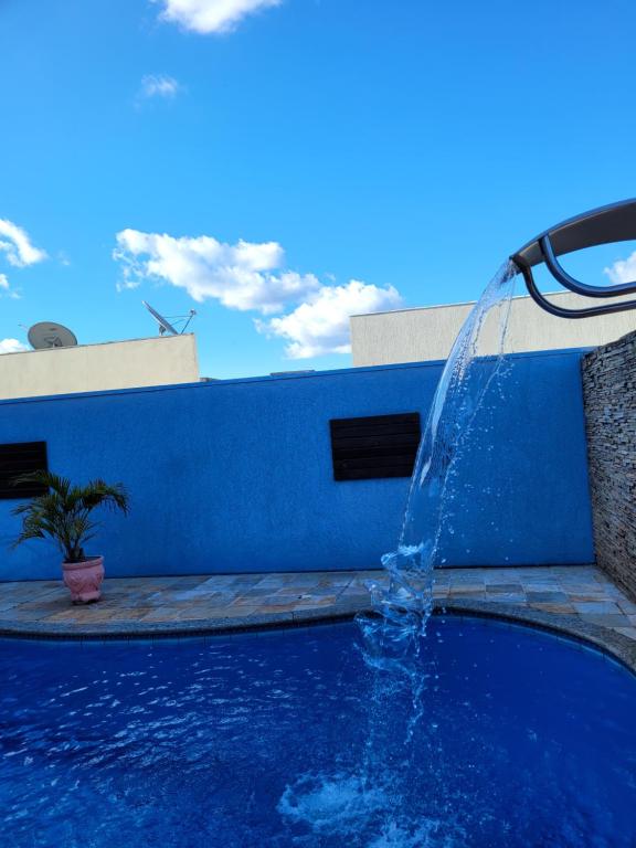 uma fonte numa piscina com uma parede azul em Casa espaçosa com linda piscina em Porto Velho