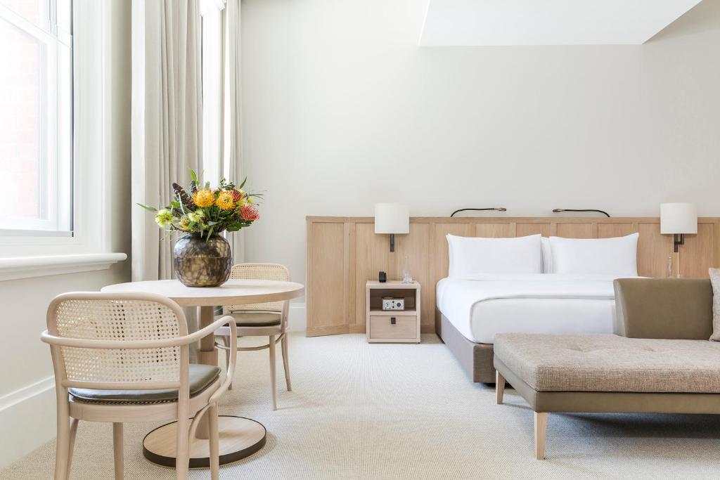 a hotel room with a bed and a table and chairs at COMO The Treasury in Perth