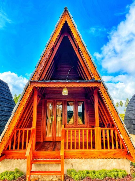 a small wooden house with a thatched roof at ANARA VILLA SAMOSIR MANAGED BY 3 SMART HOTEL in Sinapuran