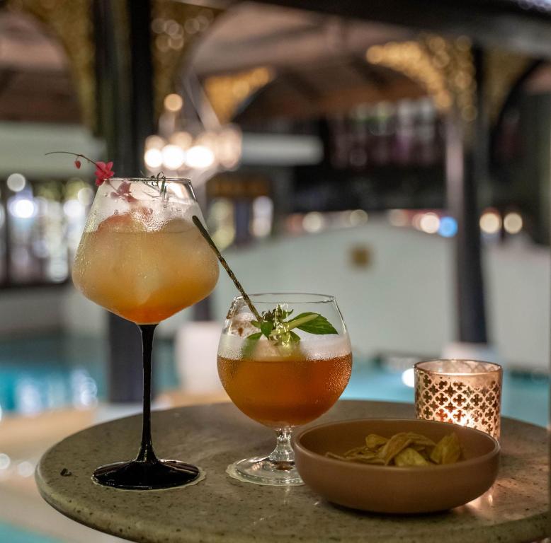 Two cocktails and a bowl of chips at a softly lit resort bar or restaurant.