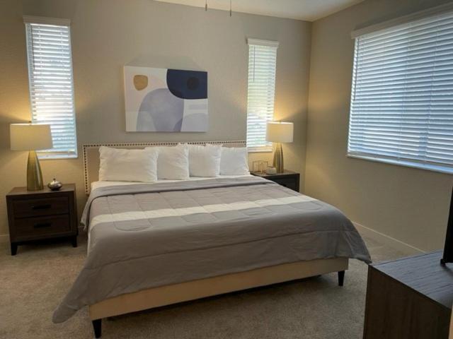 a bedroom with a large bed and two windows at Stylish Modern 3bd-2ba With Amenities in Daytona Beach