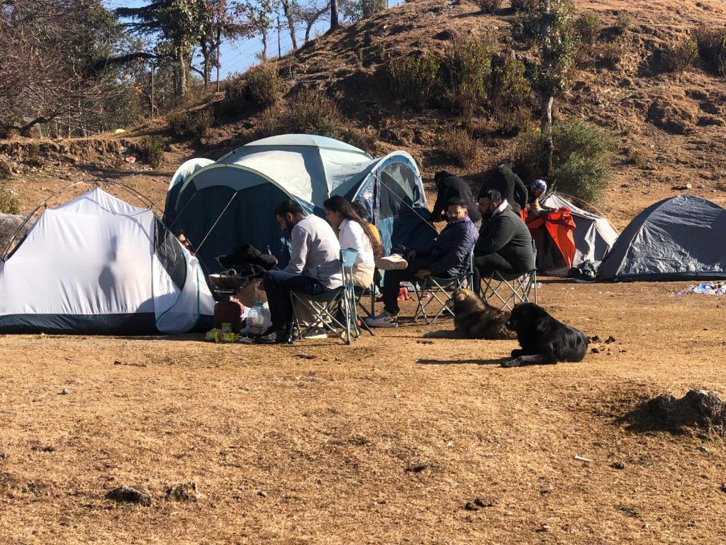 a group of people sitting in chairs in front of tents at Shivoham valley view camps in Mussoorie