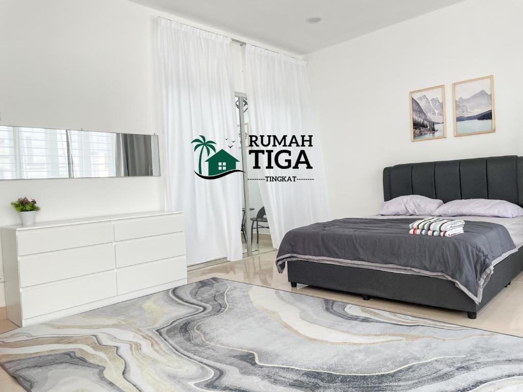a white bedroom with a bed and a rug at Rumah Tiga Tingkat in Kuantan