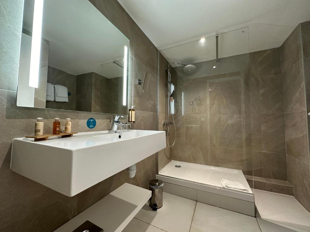 a bathroom with a sink and a shower and a toilet at Hôtel Exsel Créolia in Saint-Denis