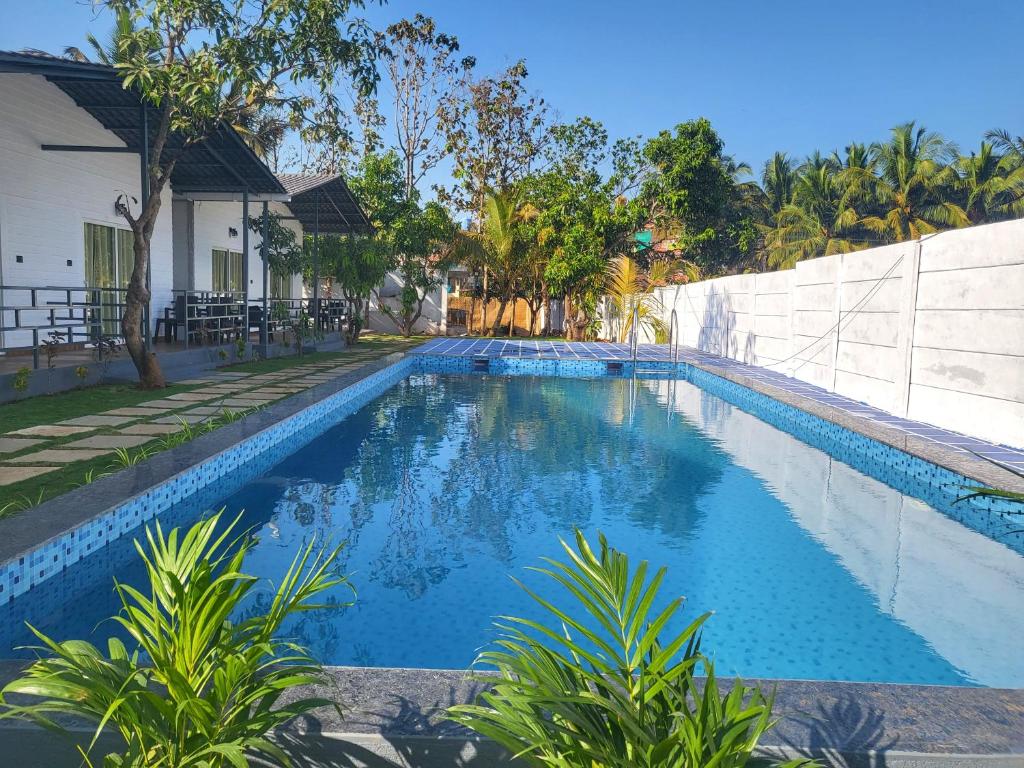 a swimming pool in front of a house at Rashiva Resort in Arambol