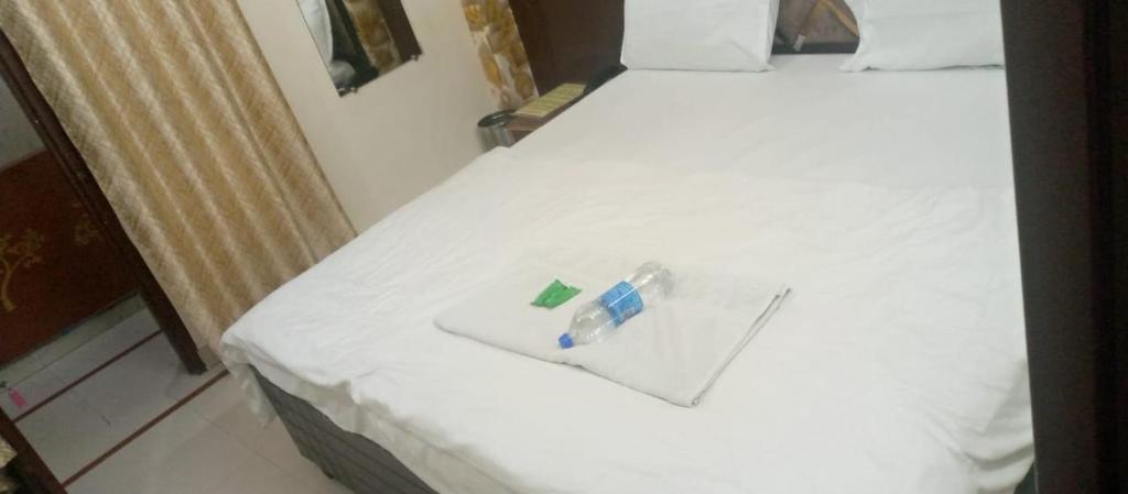a white bed with a bottle of alcohol on it at Hotel king palace in Chandīgarh
