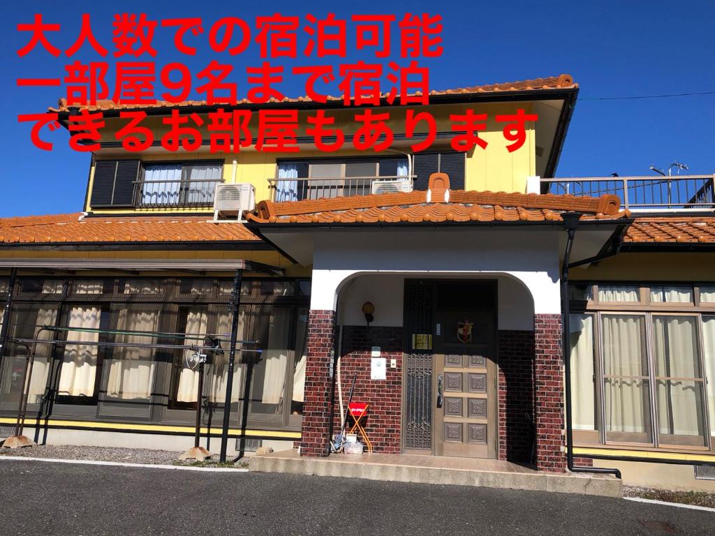een gebouw met een rood bord erop bij 楠のおうち in Yokkaichi
