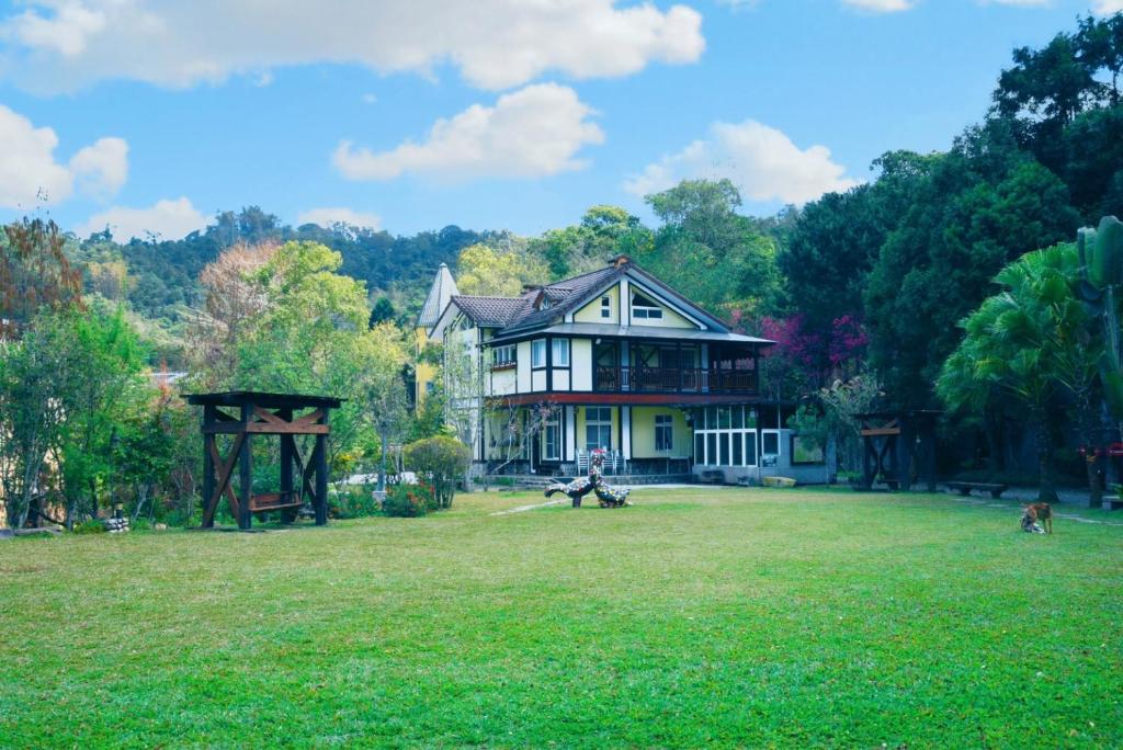 埔里鎮的住宿－佳園渡假山莊，坐在院子内长凳上的人的房屋