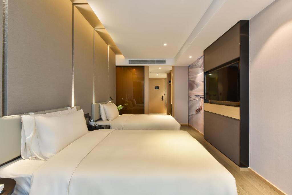 pokój hotelowy z 2 łóżkami i telewizorem w obiekcie Atour Hotel Beijing Chaoyangmen w Pekinie