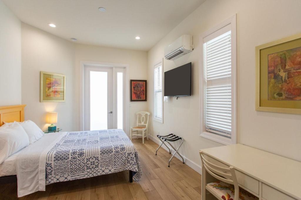 une chambre avec un lit, un bureau et une télévision dans l'établissement Sorrento Cabana, à Naples