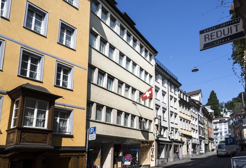 a building on a street with a canadian flag at Hotel Elite in St. Gallen