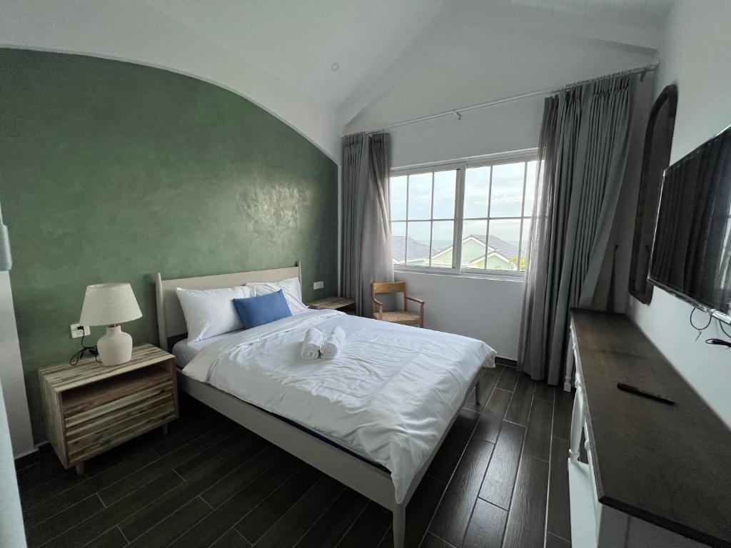 Seamoni Seaview Villa 01 - Novaworld Phan Thiết في فان ثيت: غرفة نوم بسرير كبير ونافذة كبيرة