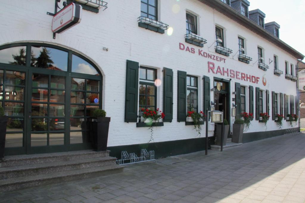 un bâtiment dans une rue avec des fleurs dans les fenêtres dans l'établissement Hotel Rahserhof, à Viersen