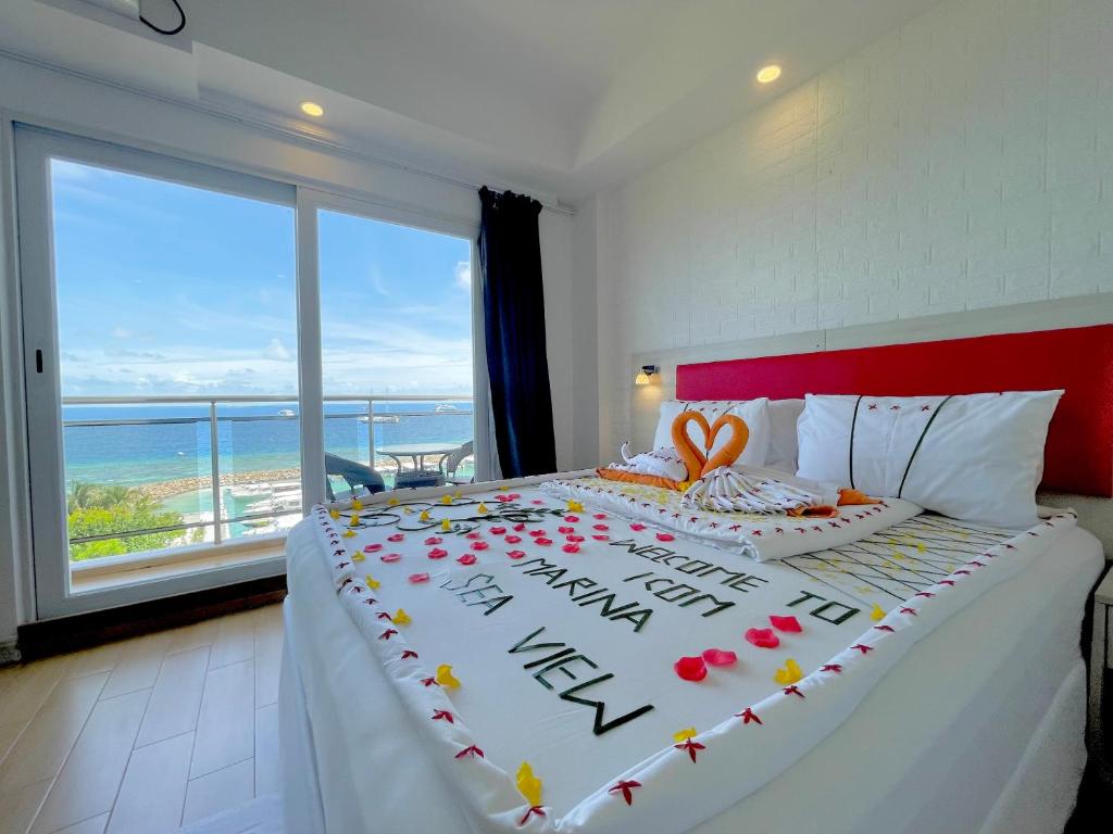 a bedroom with a bed with a view of the ocean at iCom Marina Sea View in Maafushi