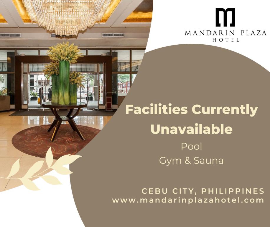 a lobby with a vase of flowers on a table at Mandarin Plaza Hotel in Cebu City