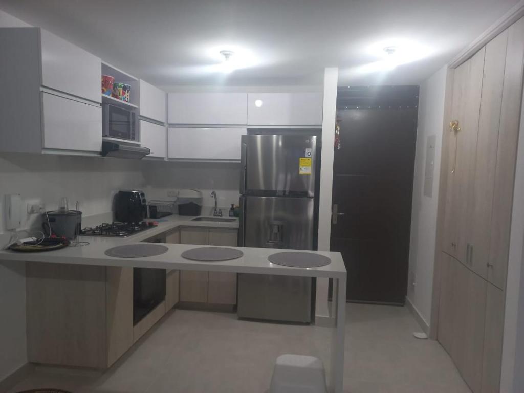 een keuken met een koelkast en een aanrecht bij Apartamento cómodo con todo lo que necesitas y con piscina in Ricaurte