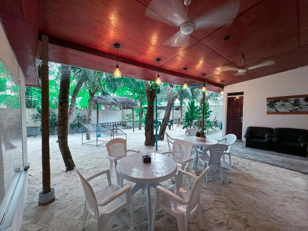 a dining room with a table and chairs and trees at Ithaa Hiya Dhihfushi in Dhiffushi