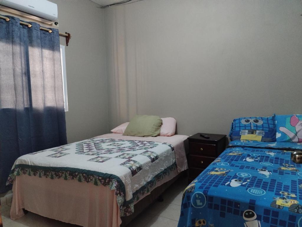 een slaapkamer met 2 aparte bedden en een raam bij Posadas Mateo in La Lima