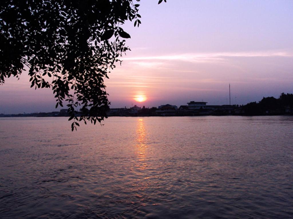 a sunset over a body of water at Baan Siriporn Resort - โรงแรมบ้านศิริพร รีสอร์ท in Samut Songkhram