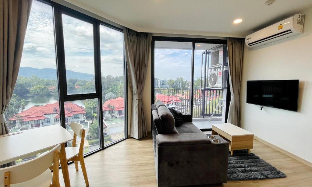 a living room with a couch and a large window at Laguna Skypark in Phuket Town