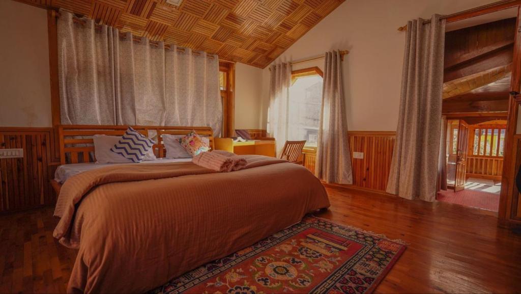 un dormitorio con una cama grande en una habitación en BARFI MANALI, en Manali