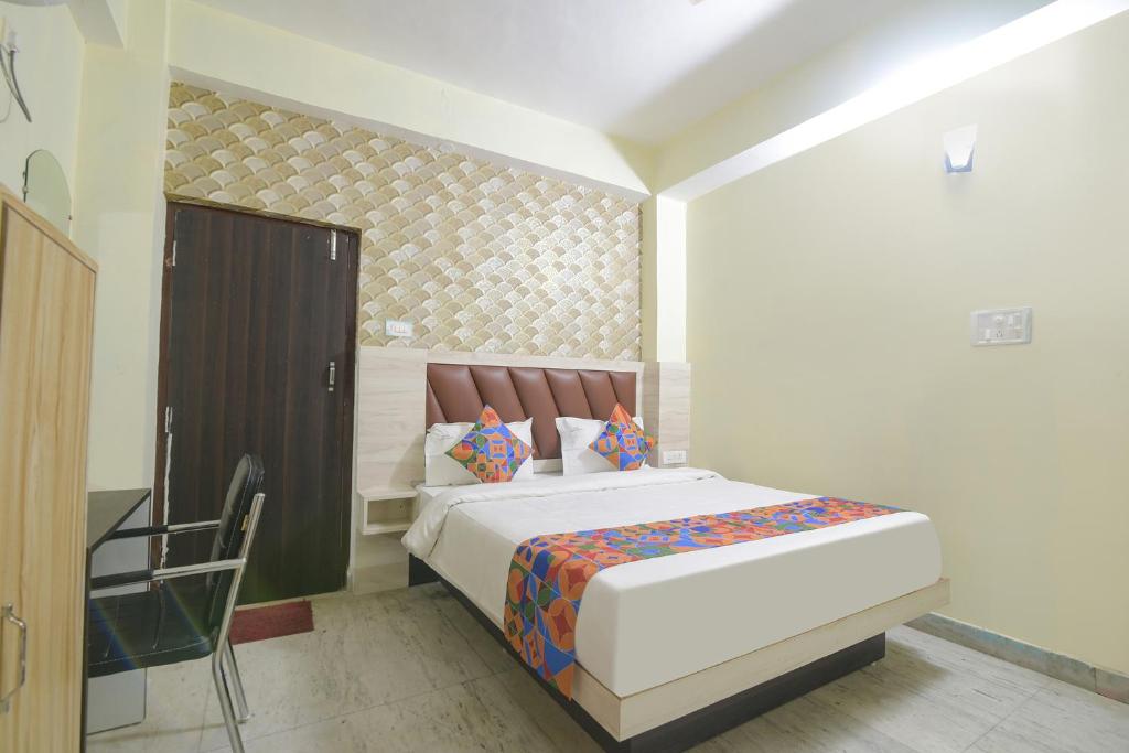 1 dormitorio con 1 cama y 1 silla en FabHotel Magadh Crystal en Patna