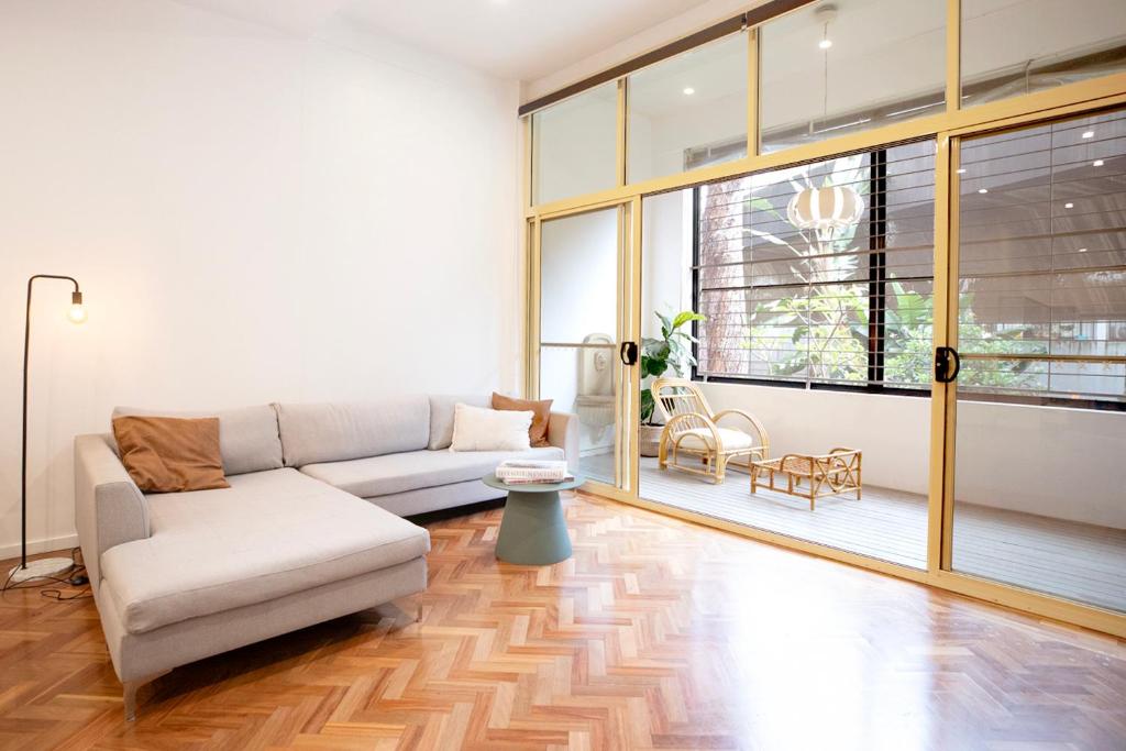 uma sala de estar com um sofá e uma grande janela em Central New York Style Warehouse em Sydney