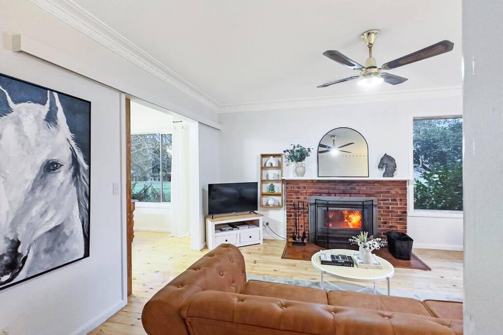 a living room with a couch and a fireplace at 'Hawthorn Park' Farm Homestead in Macedon Ranges in Romsey