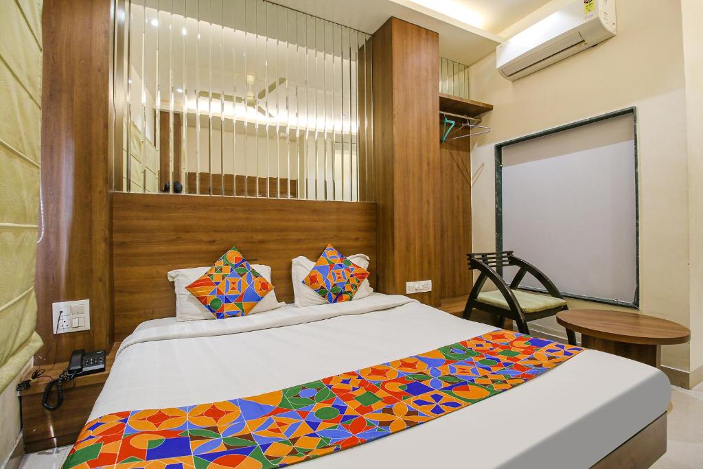 a bedroom with a bed with a colorful blanket at FabHotel Royal Palace II in Bhopal