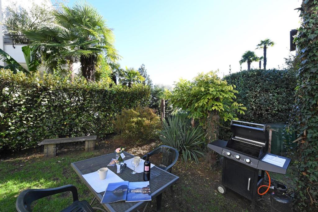 una barbacoa y una parrilla en un patio en Apartment View And Pool - Happy Rentals en Agno