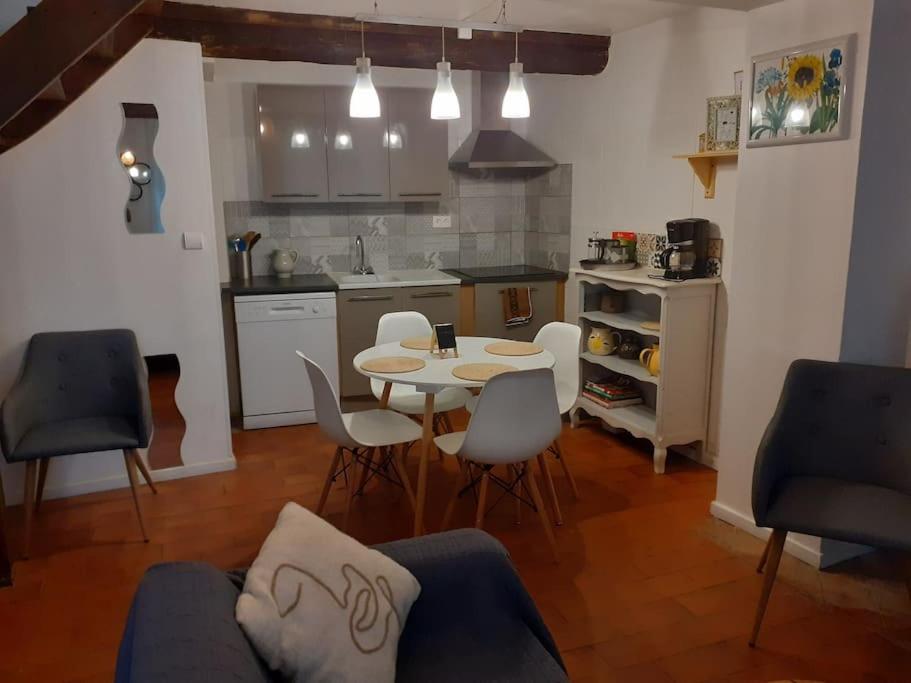 una cucina e una sala da pranzo con tavolo e sedie di Maison chaleureuse près de lagrasse corbières a Saint-Pierre-des-Champs