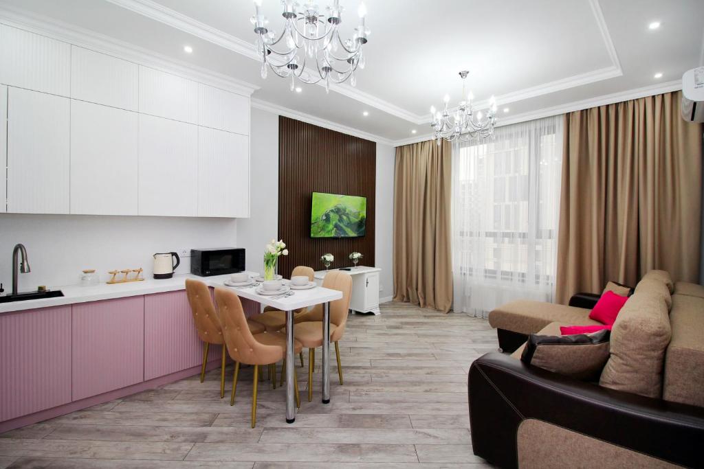 a kitchen and a living room with a table at Апартаменты бизнес-класса в ЖК Amir in Almaty