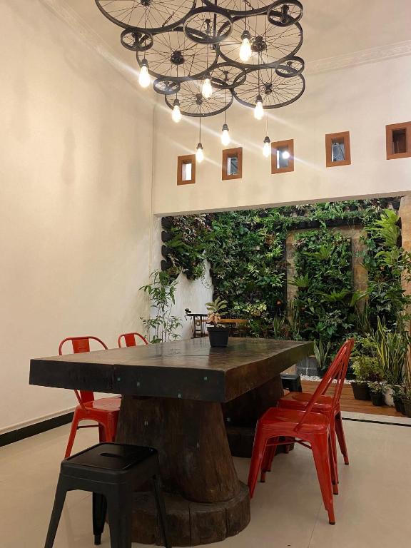 una sala da pranzo con tavolo in legno e sedie rosse di ReVive by Snooze a Banyuwangi