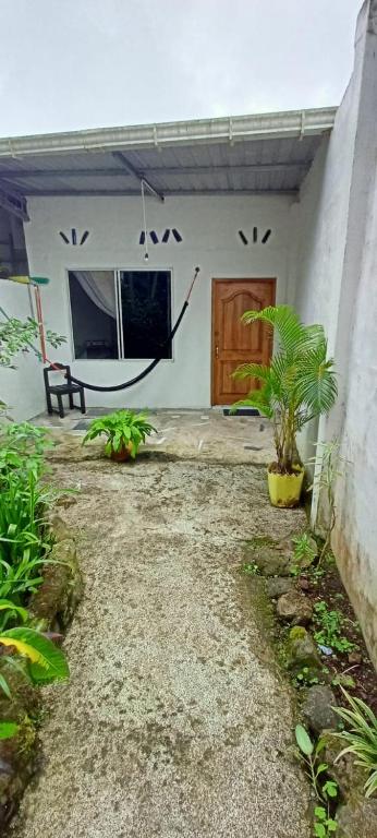 a white house with a door and a plant at Casa de campo en Bellavista in Puerto Ayora