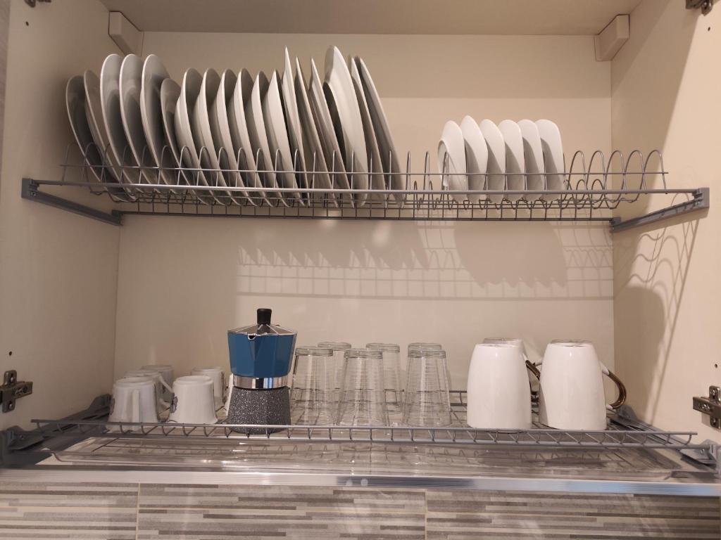 a shelf with plates and cups on it at Appartamento c&y Monte san Gabriele in Novara