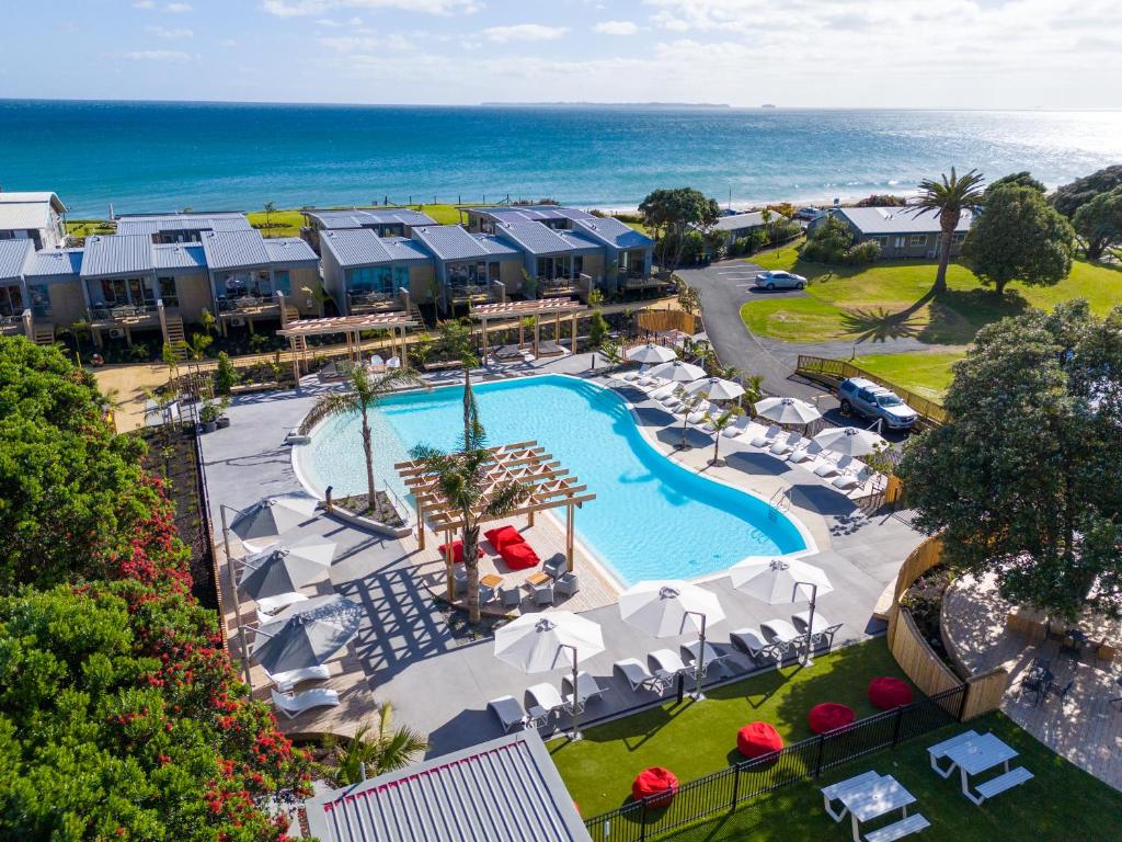 - une vue aérienne sur un complexe avec une piscine et l'océan dans l'établissement Tasman Holiday Parks - Papamoa Beach, à Papamoa