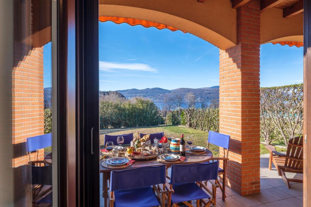 a table on a patio with a view of the mountains at La Luna nel Lago Lake View Garden - Happy Rentals in Ispra