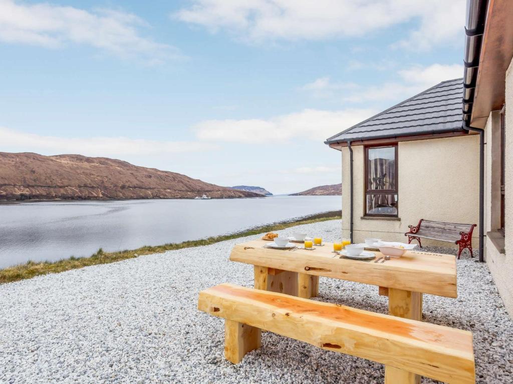 a picnic table with a view of a body of water at 3 Bed in Broadford 81181 in Luib