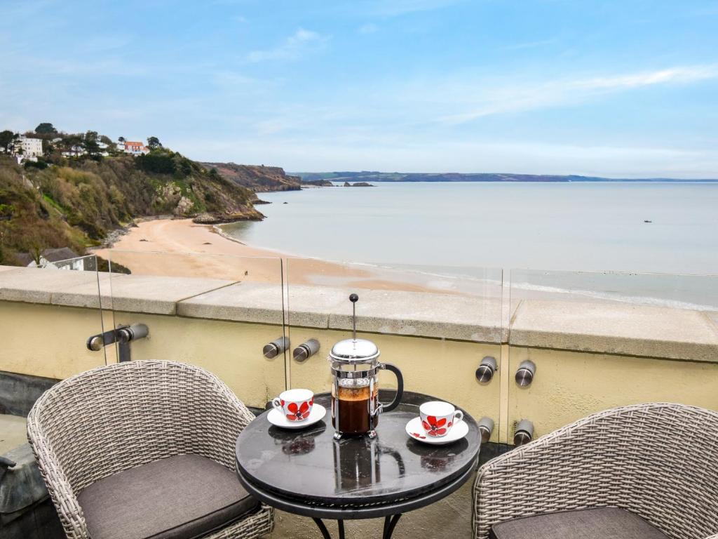 a table with two chairs and a coffee maker on a balcony at 3 Bed in Tenby FB273 in Tenby