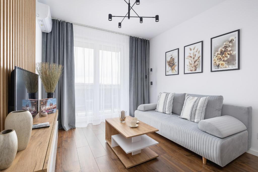 a living room with a couch and a table at Near EXPO Cracow Elegant Apartment by Renters in Krakow