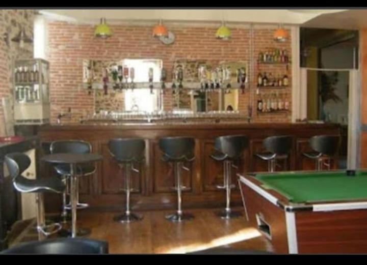 a bar with a pool table and some bar stools at Le Domaine in Moustey