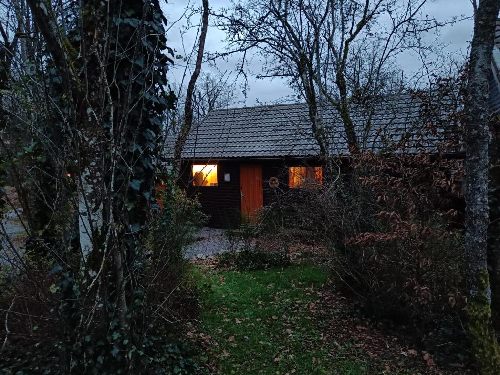 a small cabin with a window in the woods at Chalet HEUREux in Somme-Leuze