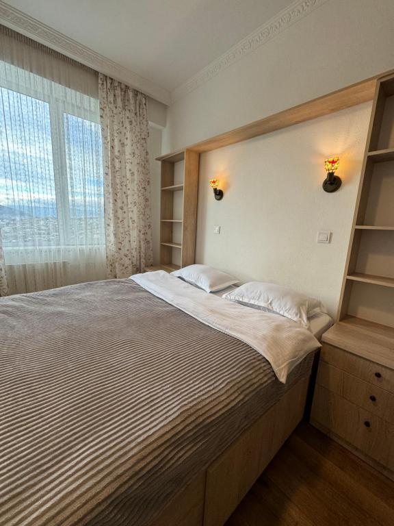 ein Schlafzimmer mit einem großen Bett und einem Fenster in der Unterkunft Tea's apartment in Tbilisi in Tbilisi City
