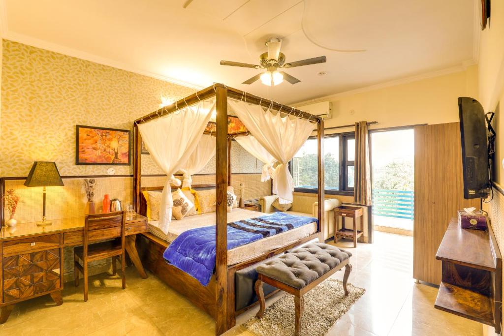 um quarto com uma cama de dossel e uma secretária em House Of Comfort Greater Noida em Greater Noida